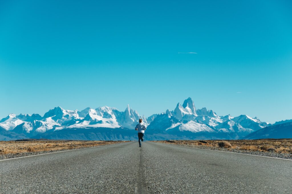 Men running on a road in the mountains