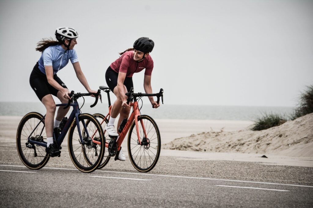 two women cycling near the beach